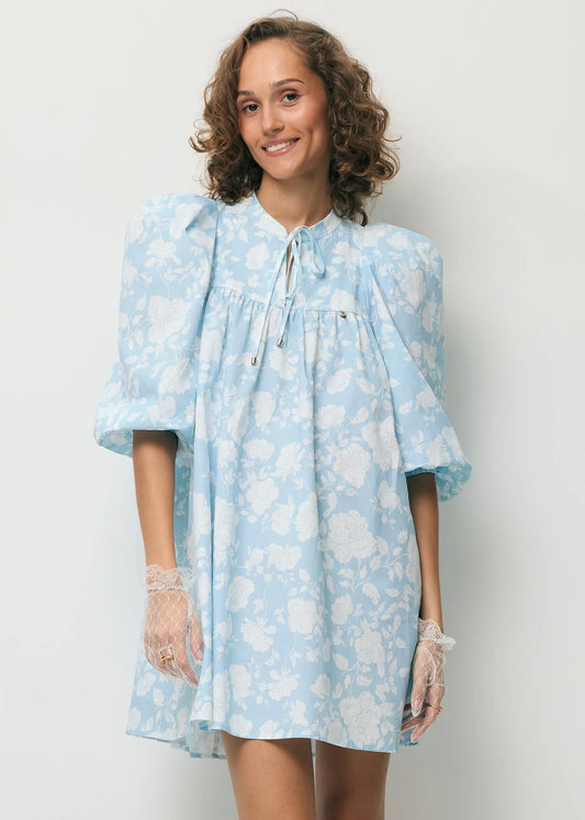 Uśmiechnięta modelka ubrana w mini sukienkę AYOTE.
