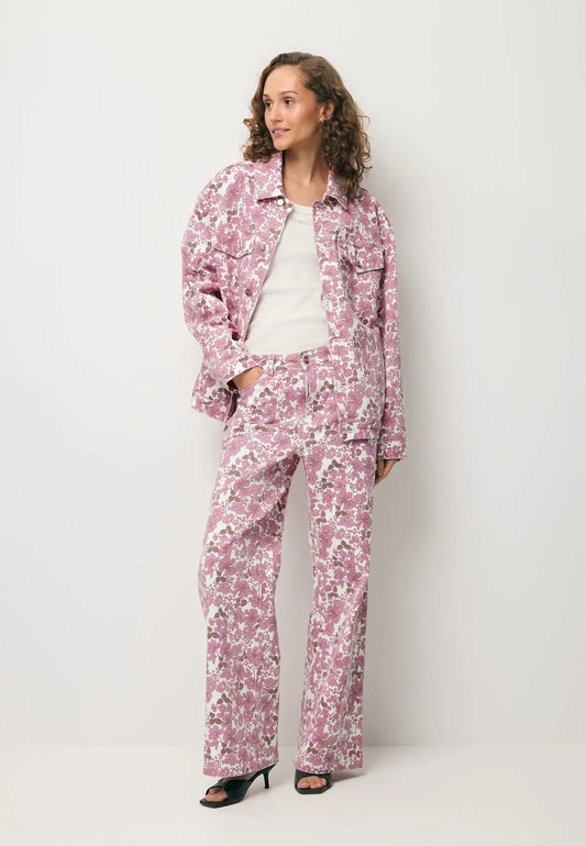 Modelka ubrana w printowane spodnie DONY, kremowy top SEYA oraz denimową kurtkę w print PRINSA.