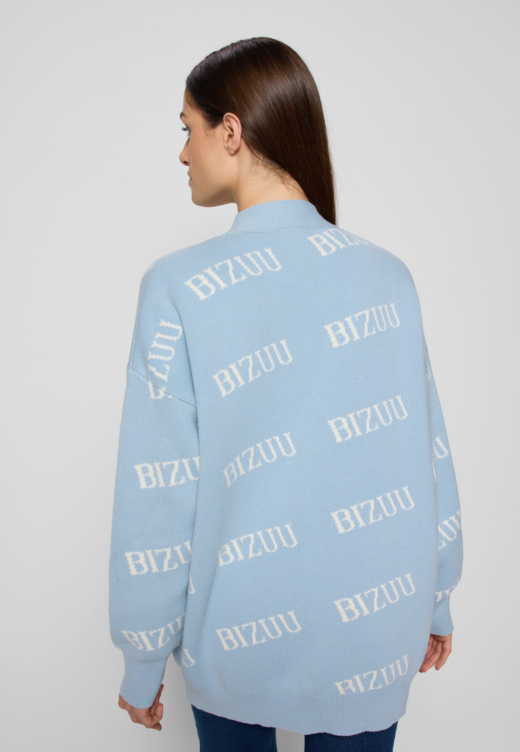 Zbliżenie na tył błękitnego swetra w logo Bizuu na modelce.