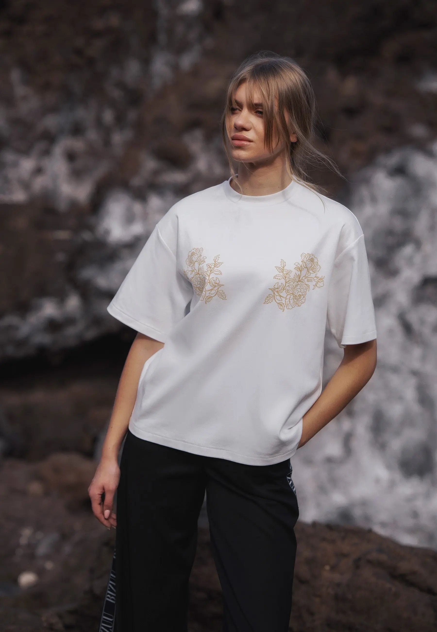 Zbliżenie na modelkę w kremowym T-shircie z autorską aplikacją FANYA.