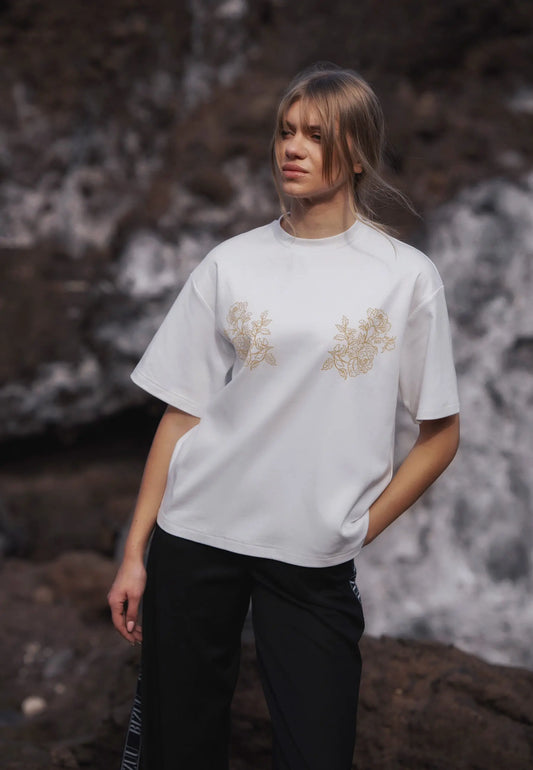 Zbliżenie na modelkę w kremowym T-shircie z autorską aplikacją FANYA.