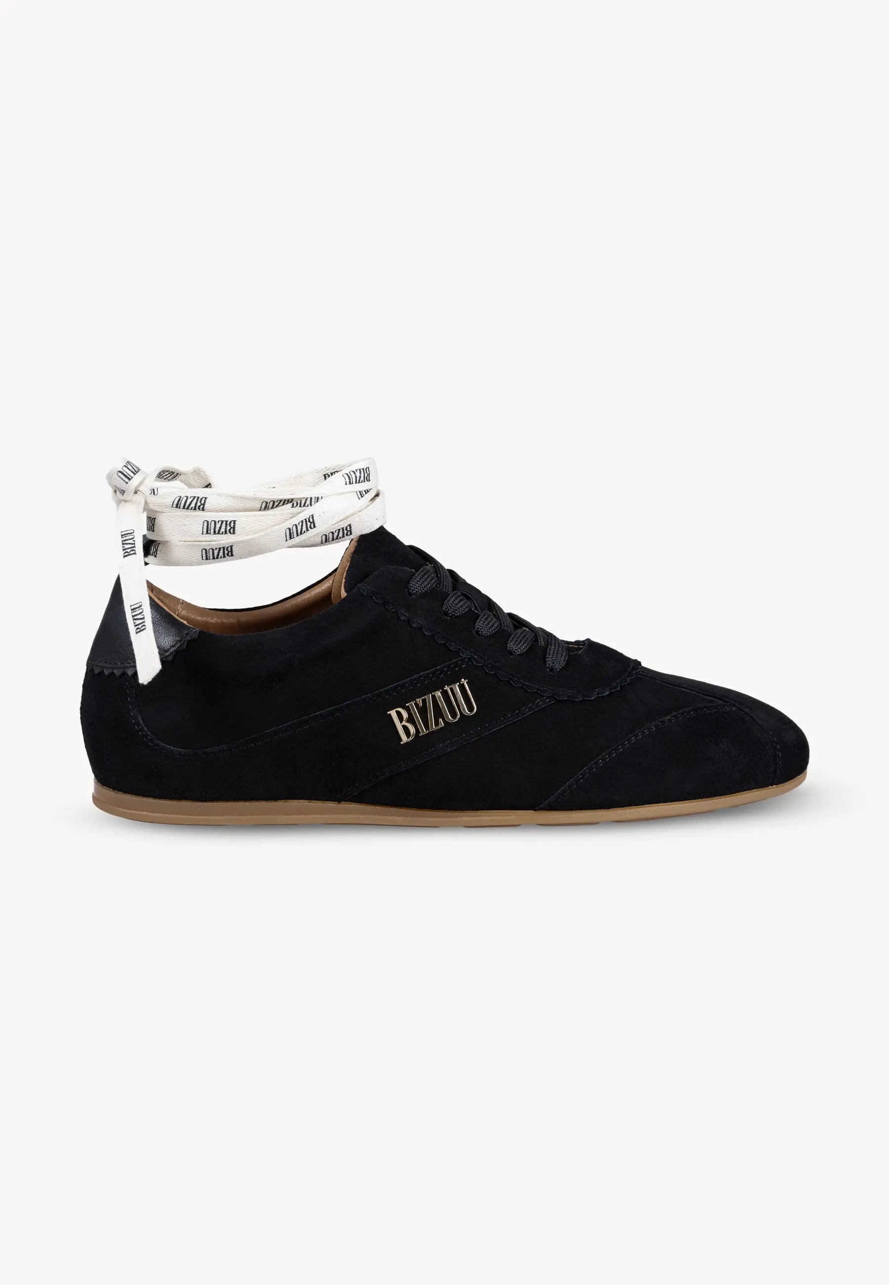 Czarne sneakersy LEOLA stojące bokiem, złote logo Bizuu na boku. But pokazany z dodatkową wstążką z logo Bizuu, którą można przewiązać na kostce.