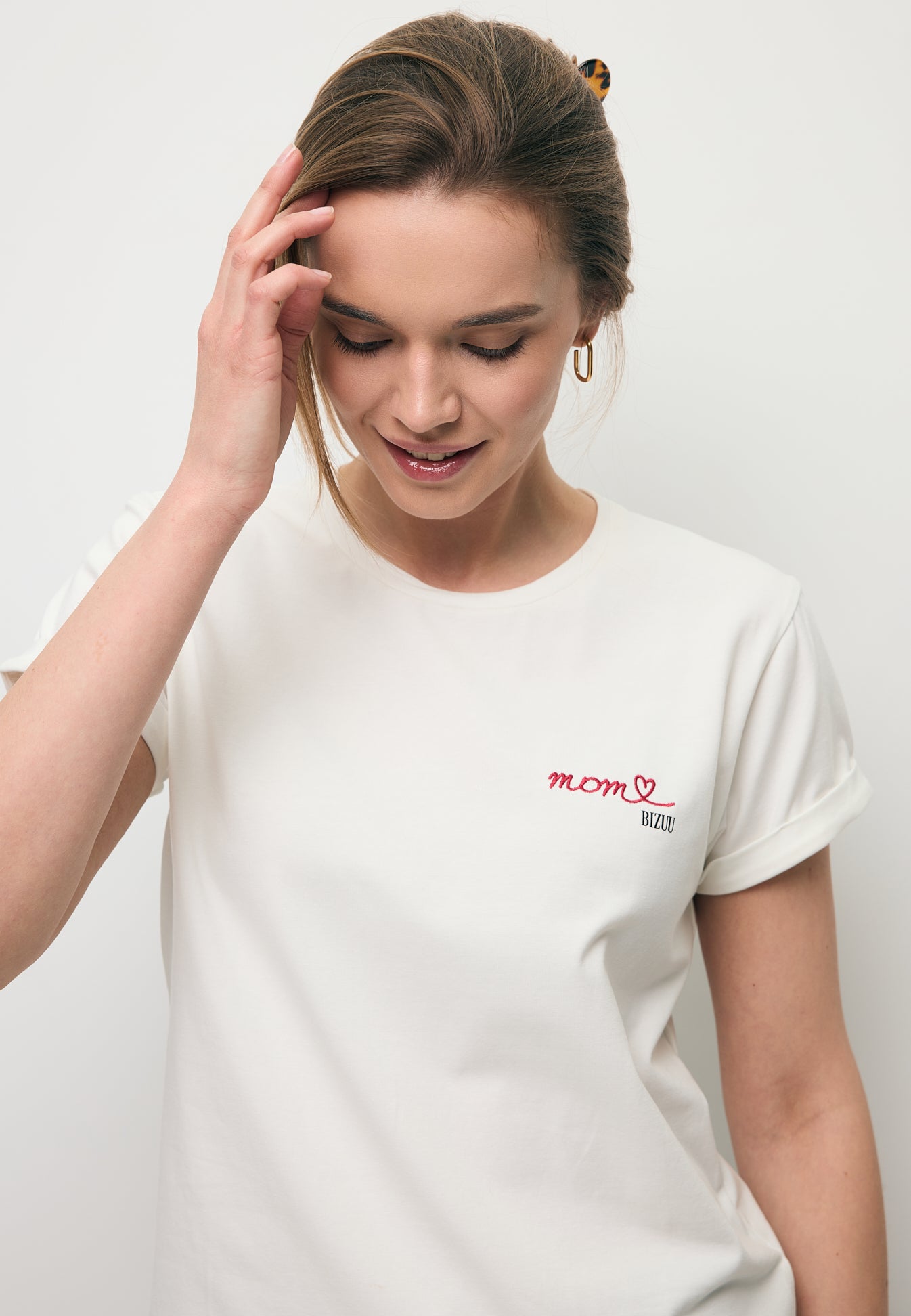 Zbliżenie na modelkę w białym T-shircie z napisem MOM.