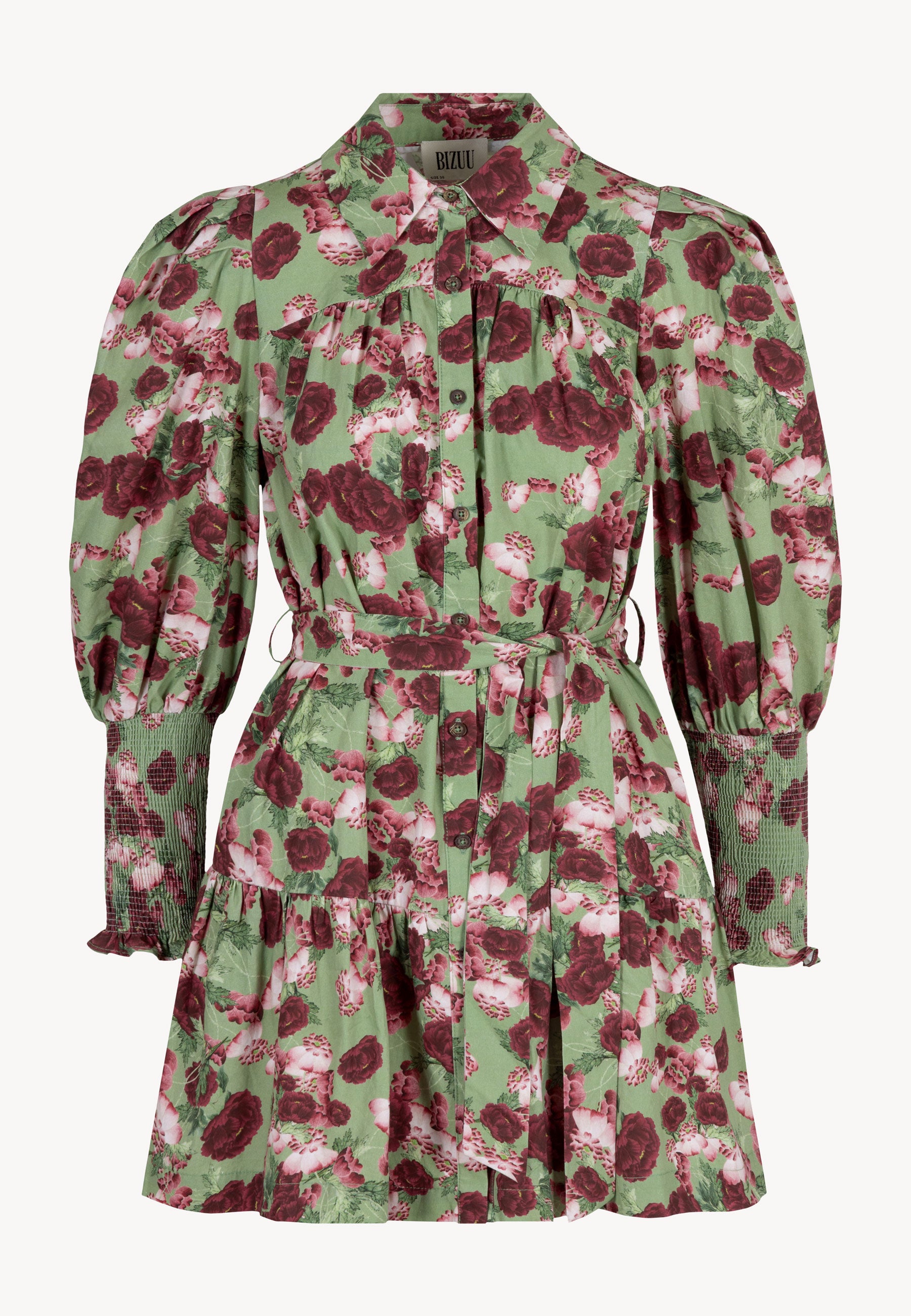 Zbliżenie na modelkę ubraną w zieloną mini sukienkę SOREZIA w kwiatowy print.